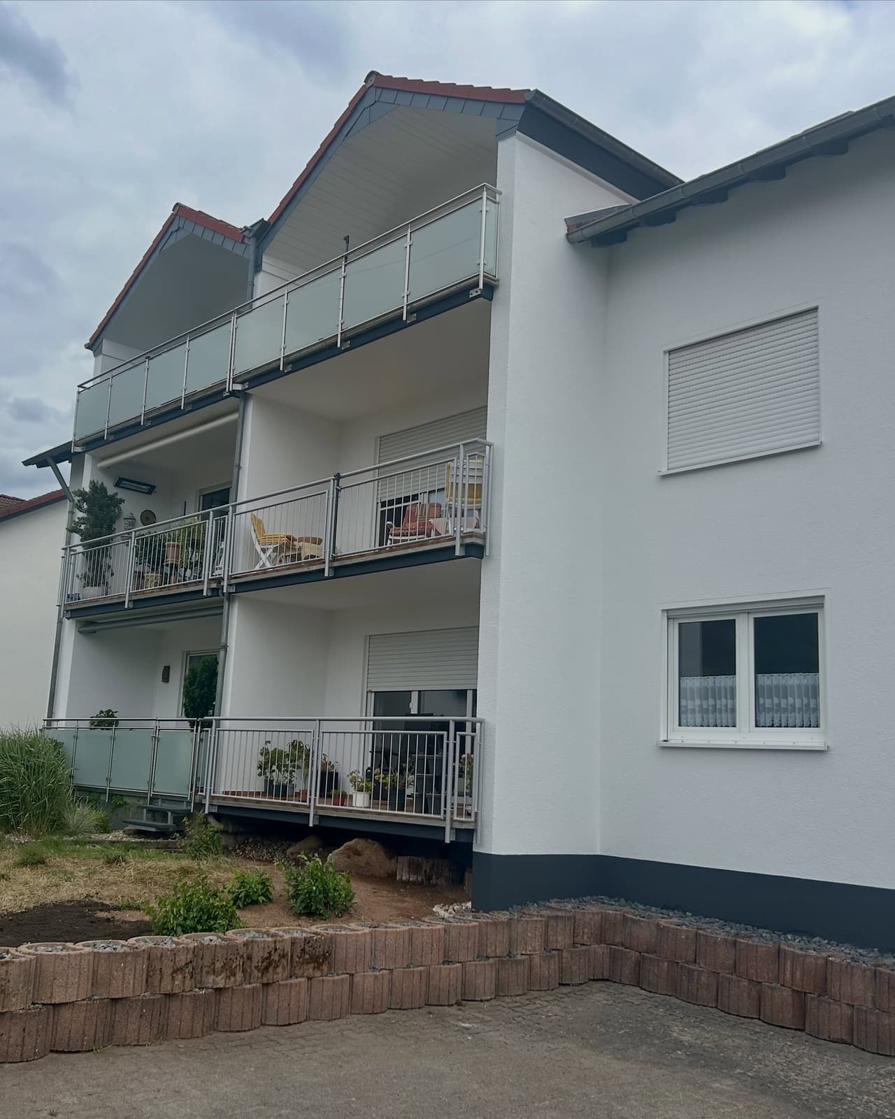 Mehrfamilienhaus mit frisch gestrichener weißer Fassade und Balkonen